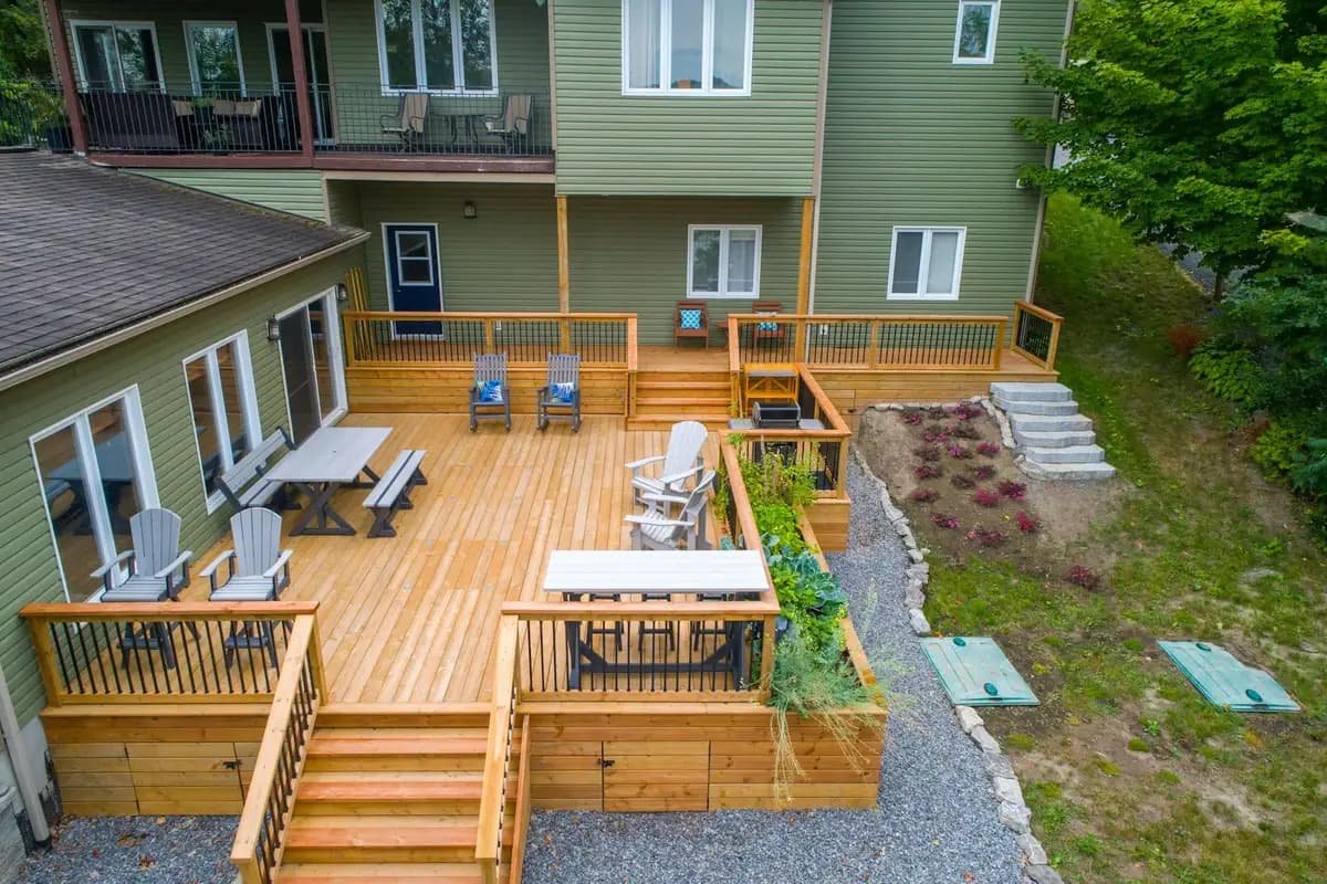 Multi-level pressure-treated wood deck with stairs, built-in planter boxes, and outdoor furniture, seen from above