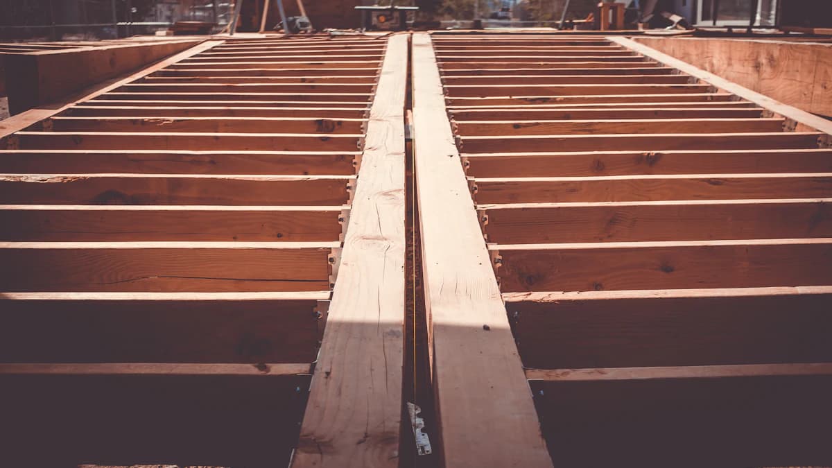 Deck floor frame under construction showing evenly spaced joists and a doubled center beam