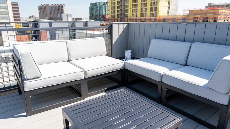 Composite rooftop deck with gray outdoor sofas and a city view