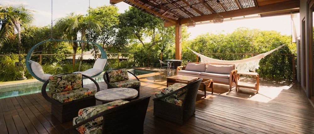 Covered deck with a pergola roof, outdoor furniture in warm evening light