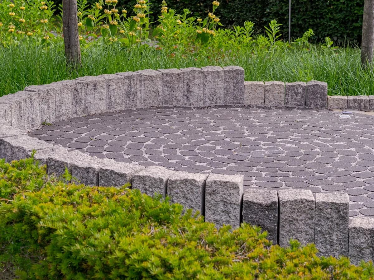 Circular stone paver patio in a landscaped backyard