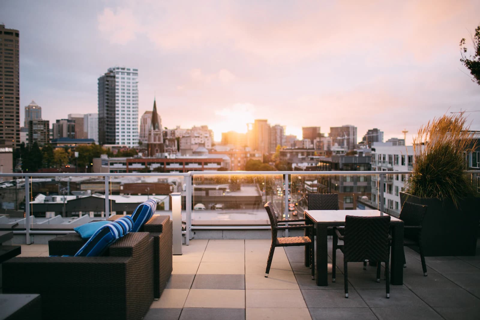 A furnished rooftop terrace deck with a patio set overlooking a city skyline