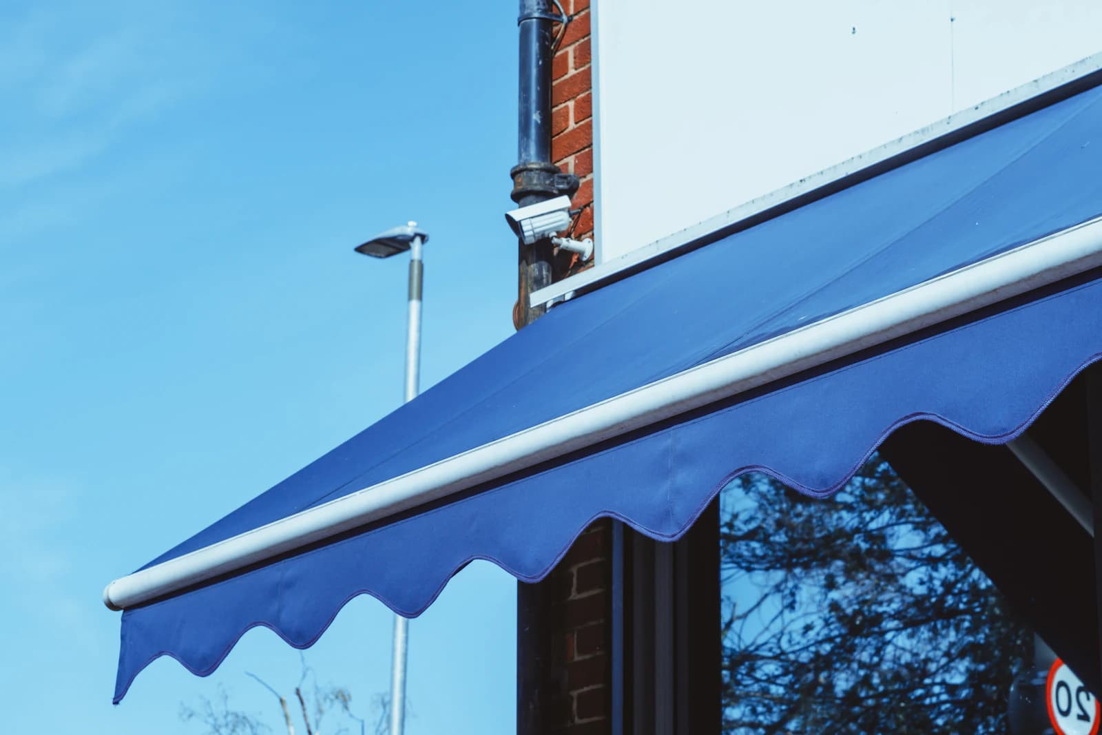 A retractable fabric awning extended over a deck to provide shade near a house