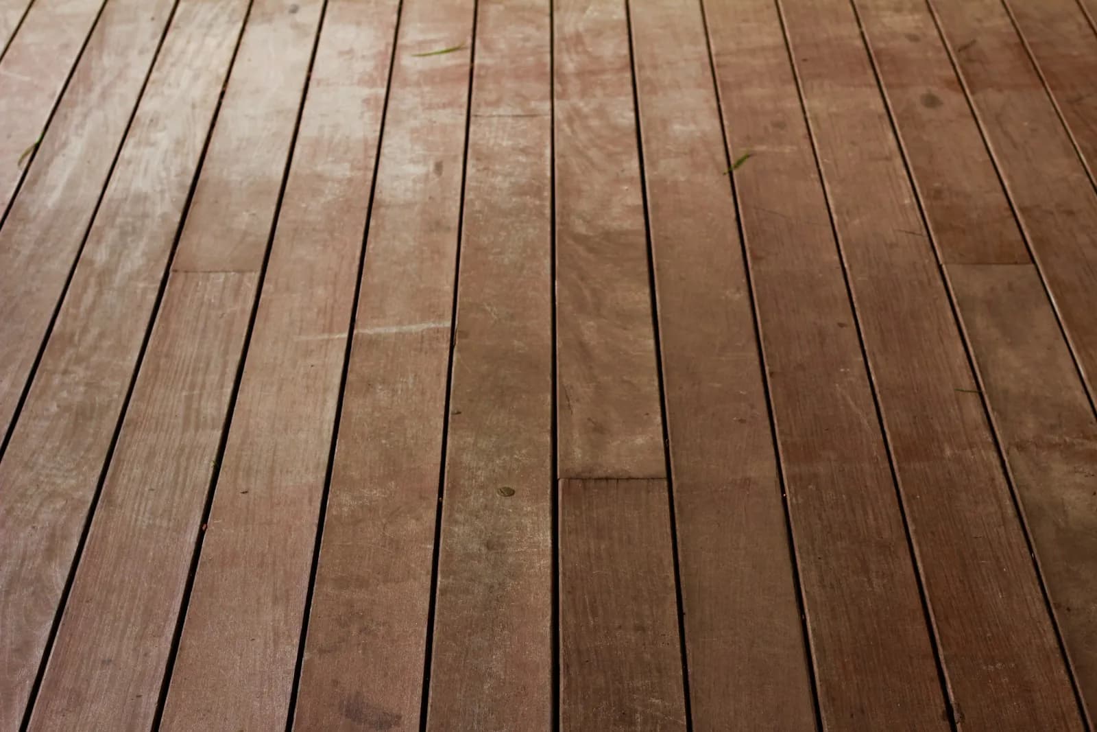 A brown wooden deck floor with boards running in parallel courses