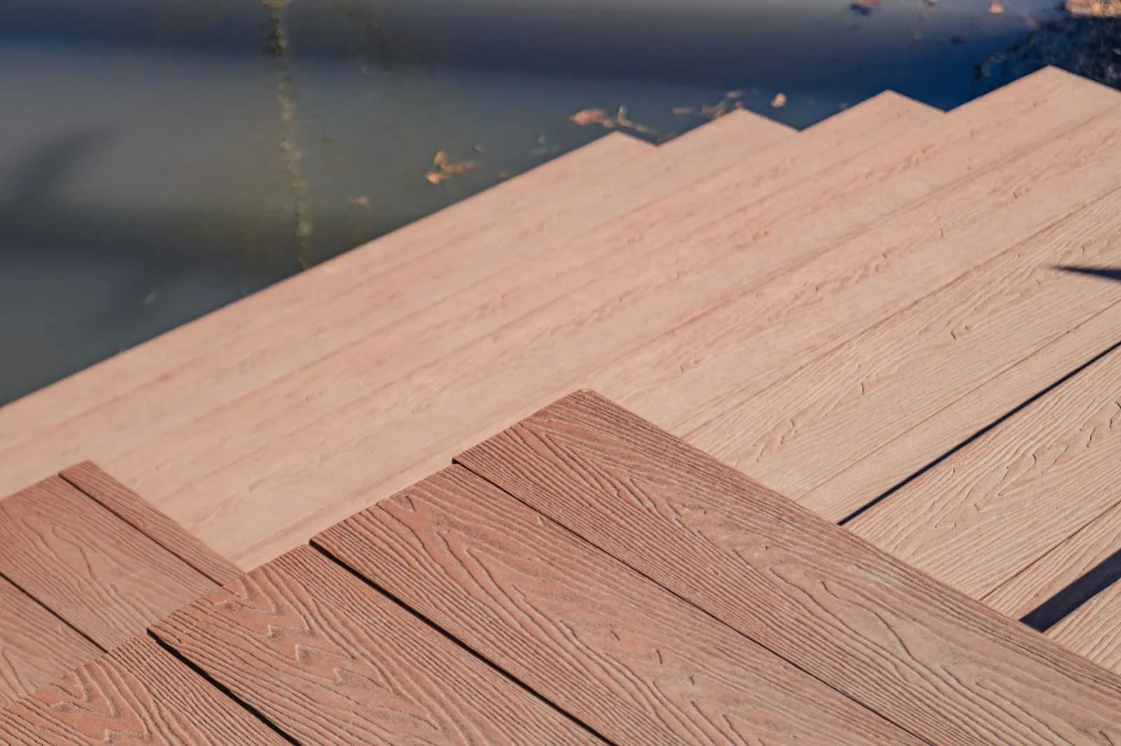 A wooden deck surface and steps with an even gap between every board
