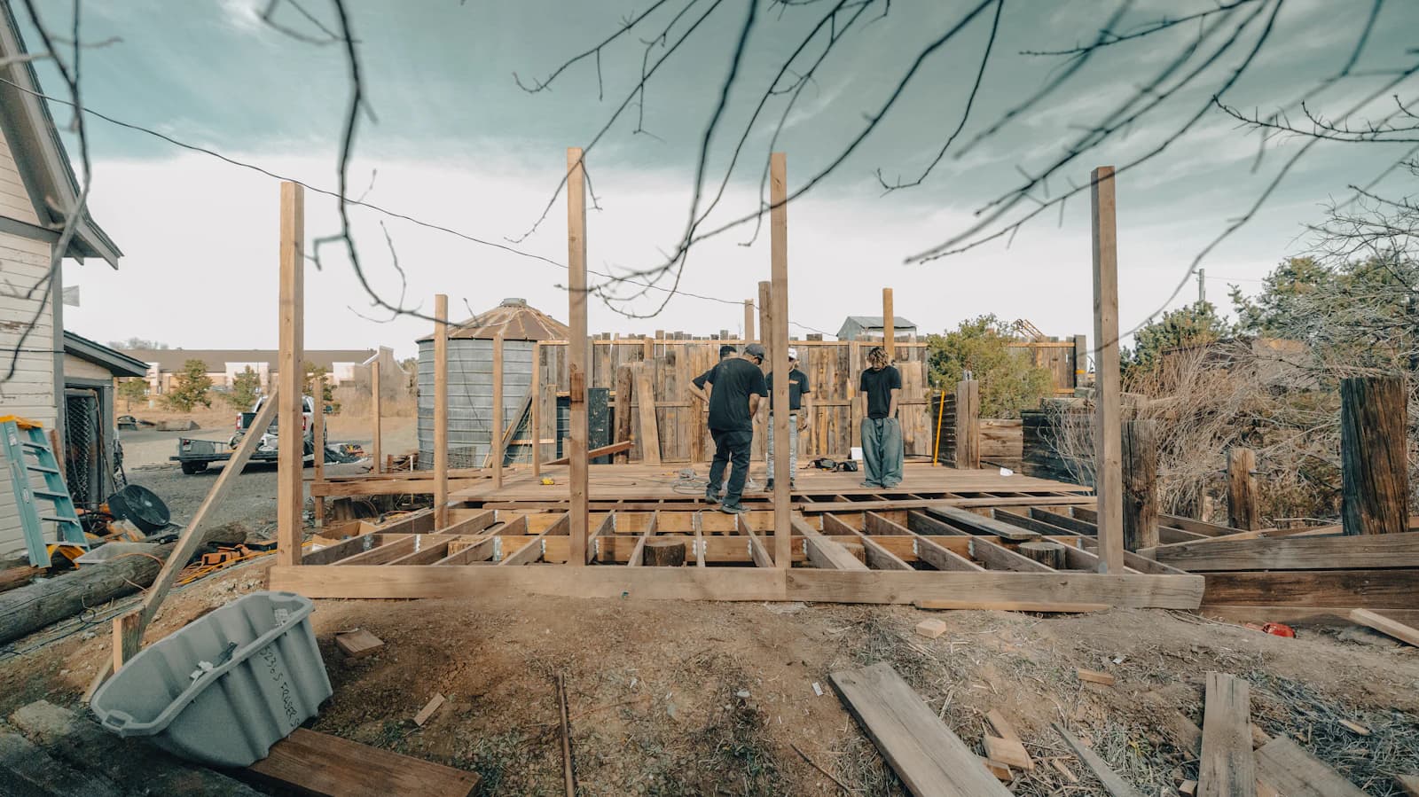 The joist and beam framing of a deck under construction, sized out on footings