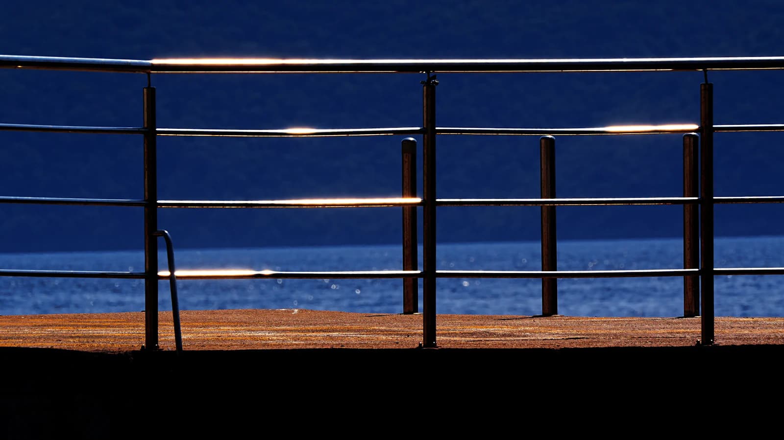 A metal deck railing — the natural mounting point for post-cap and under-rail lights