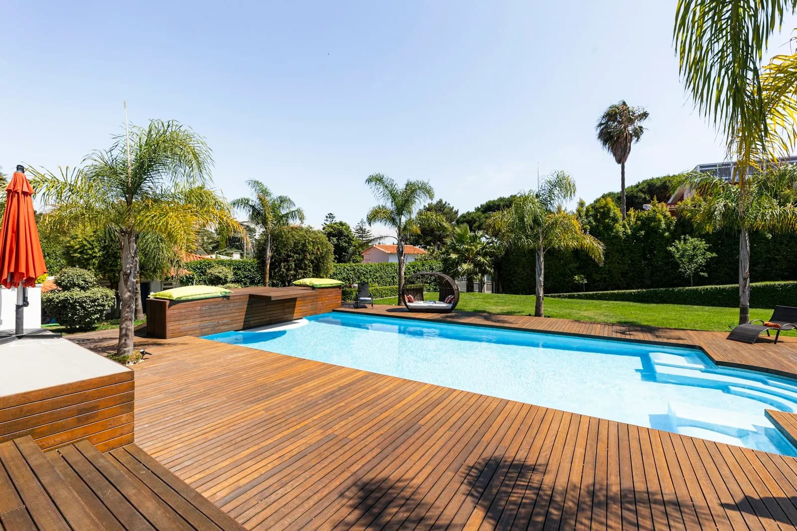 A hardwood pool deck in a sunny backyard with a clean, fastener-free board surface