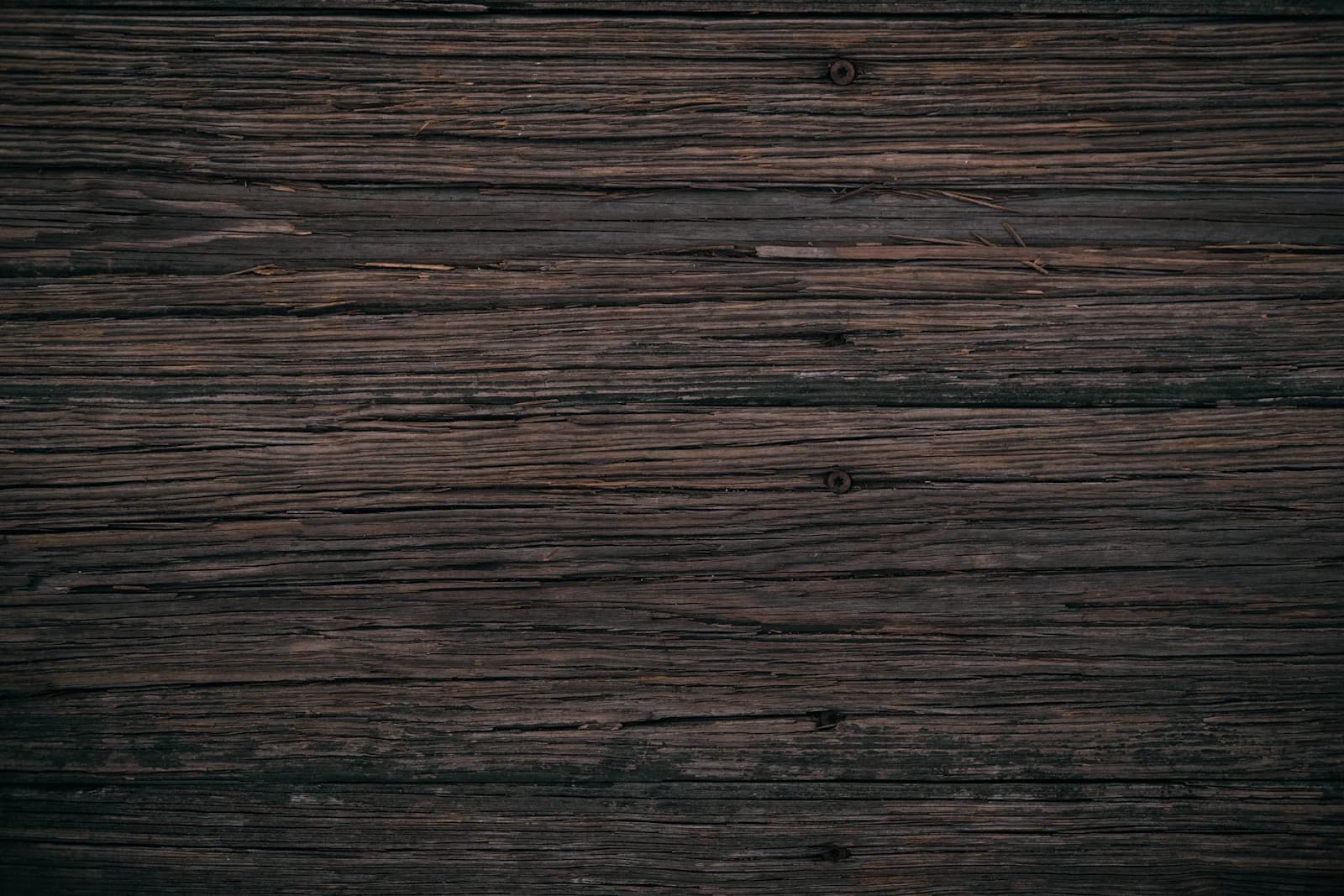 A weathered, silver-gray wooden deck showing sun and moisture wear before refinishing